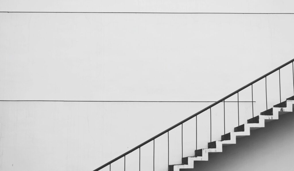 Minimalistic black and white staircase with sharp angles and clean lines, showcasing modern architecture.
