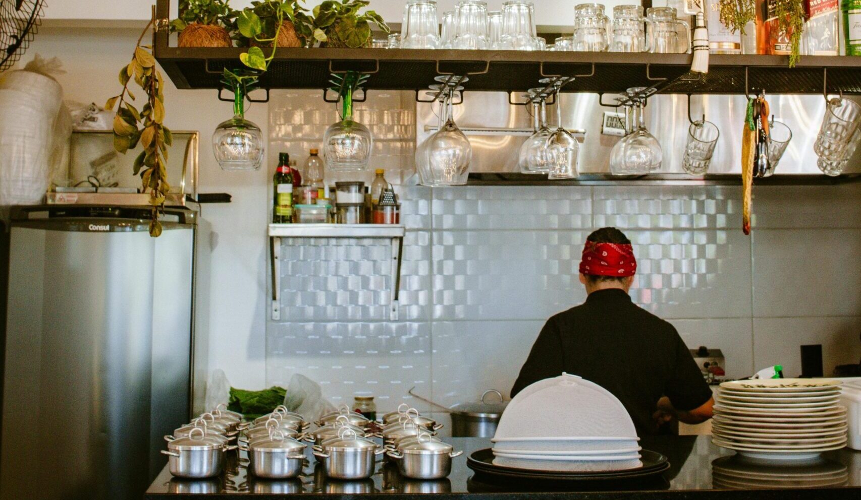 Stylish restaurant interior featuring a chef preparing dishes behind a counter.